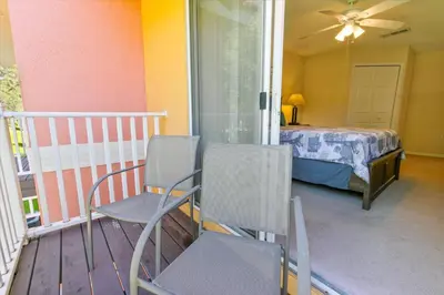 a room with two chairs and a bed on a balcony at SKP2764 in Kissimmee