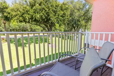a porch with two chairs and a fence at SKP2764 in Kissimmee