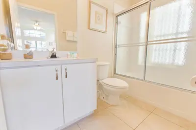 a white bathroom with a toilet and a shower at SKP2764 in Kissimmee