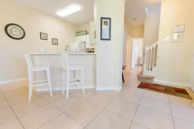 a kitchen with a counter and chairs in a room at SKP2764 in Kissimmee