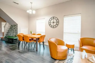 a dining room with a table and chairs and a clock at Full House HotTub Mins to UCF in Bithlo