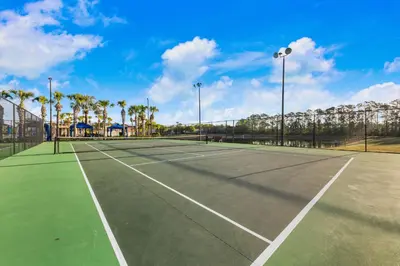 a tennis court with palm trees in the background at Wonderful 4 bed Family Home with Private Pool in Kissimmee