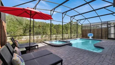 a swimming pool with a red umbrella and a swimming pool at OMW2718 in Kissimmee