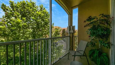 a balcony with a chair and a tree at ALM2788-301 in Orlando