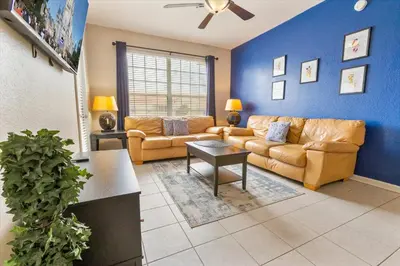 a living room with couches and a blue wall at ALM2784-404 in Orlando