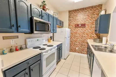 a kitchen with blue cabinets and white appliances at ALM2784-404 in Orlando