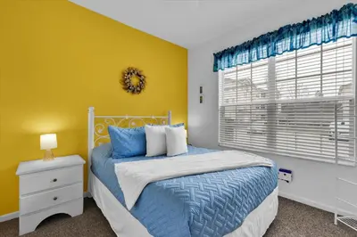 a bedroom with a bed and a yellow wall at SPD2319 in Kissimmee