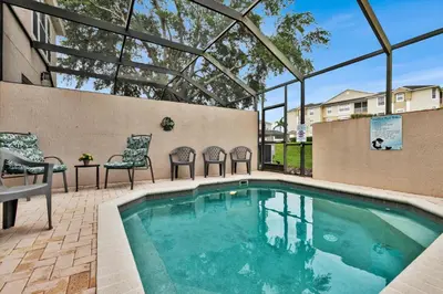a swimming pool with two chairs and a table and a tablektop at SPD2319 in Kissimmee