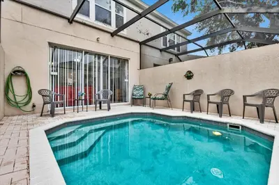 a swimming pool with chairs and a table at SPD2319 in Kissimmee