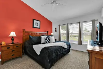 a bedroom with orange walls and a bed and a television at SPD2319 in Kissimmee