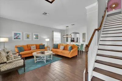 a living room with orange furniture and a staircase at TT7752 Windsor Hills Resort 6br in Orlando