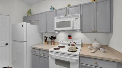 a kitchen with a white stove and a microwave at BF2302-203 Windsor Palms Resort 3 Bedroom in Kissimmee