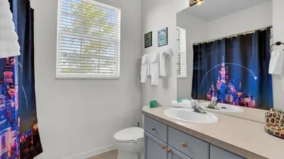 a bathroom with a sink and a toilet and a window at BF2302-203 Windsor Palms Resort 3 Bedroom in Kissimmee
