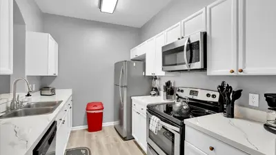 a kitchen with white cabinets and a stainless steel refrigerator at BF2301-301 Windsor Palms Resort 3 Bedroom in Kissimmee