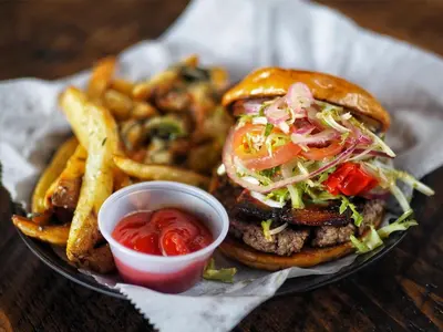 a plate of food with a hamburger and french fries at The Famous Houseboat in Sanford in Sanford