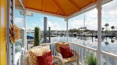 a porch with two chairs and a view of a marina at The Famous Houseboat in Sanford in Sanford