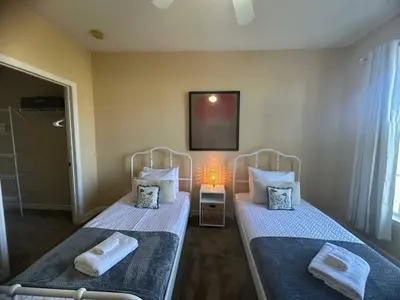 two twin beds in a bedroom with a lamp at Cozy condo Just a few minutes from Disney in Kissimmee