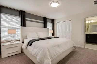 a bedroom with a large white bed and a window at 4QT Elegante Casa c/ Piscina – 10 Min da Disney! in Kissimmee