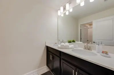 a bathroom with a sink and a mirror at 4QT Elegante Casa c/ Piscina – 10 Min da Disney! in Kissimmee