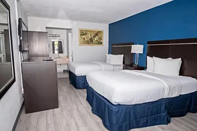 two beds in a hotel room with blue walls at Palm Tree Inn Altamonte Springs Orlando in Orlando