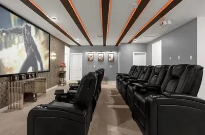 a cinema room with black leather chairs and a screen at 2525 Shanti Amazing 15 Suites Mansion in Kissimmee