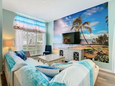 a living room with a couch and a palm tree mural at Group retreat w pool, spa & BBQ in Orlando