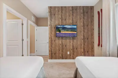 a bedroom with two beds and a painting on the wall at Minutes to Disney Chic Dream Villa with Stunning Patio and Resort Perks in Orlando