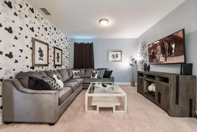 a living room with a couch and a tv at Elegant 8BR Encore Resort Pool w Spa GameRoom Single Family in Orlando