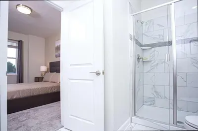 a bathroom with a shower with a glass door at Epic Dream Home with Spa Game Room Themed Bedrooms 2887 Single Family in Kissimmee