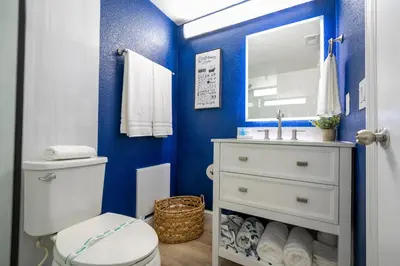 a bathroom with blue walls and a toilet and a sink at Luxury Lakeview Getaway 1 mile Universal Studios in Orlando
