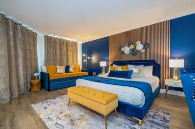 a blue bedroom with a large bed and a yellow chair at Luxury Lakeview Getaway 1 mile Universal Studios in Orlando