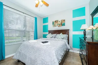 a blue and white bedroom with a bed and a window at Vacation Villa Near Disney With Private Pool Spa in Kissimmee