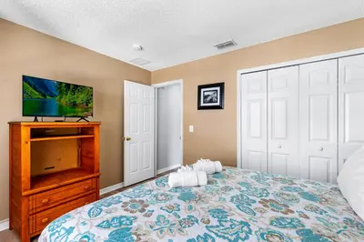 a bedroom with a bed and a flat screen tv at Disney Doorstep 7 Bedroom Villa with SouthFacing Pool and Hot Tub in Kissimmee