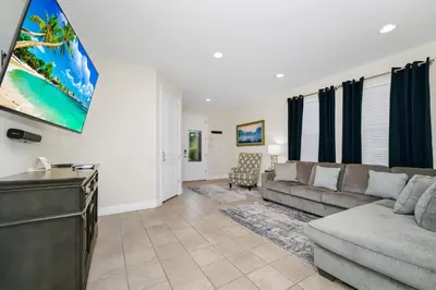 a living room with a couch and a flat screen tv at Welcoming Home With Game Room And Private Pool With Water Park Access At Encore Resorts Reunion - 150Mn in Kissimmee