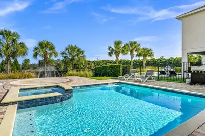 a swimming pool with a fountain in a yard at Marvelous Home With Media Room, Theme Room And Waterpark & Resort Access Near Disney At Encore Resorts Reunion - 7485Mr in Kissimmee