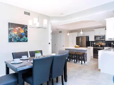 a kitchen and dining room with a table and chairs at Amazing Townhome With Lake View At Storey Lake Resort in Kissimmee