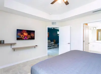 a bedroom with a bed and a tv on the wall at Amazing Townhome With Lake View At Storey Lake Resort in Kissimmee