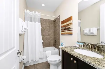 a bathroom with a white toilet and a sink at Extravagant Home With Movie Theater, Private Pool And Waterpark & Resort Access At Encore Resort - 241Fl in Kissimmee
