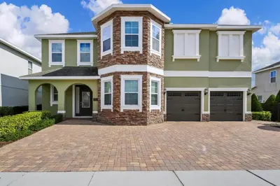 a house with a brick driveway in front of it at Extravagant Home With Movie Theater, Private Pool And Waterpark & Resort Access At Encore Resort - 241Fl in Kissimmee