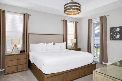 a bedroom with a large white bed and windows at Magnificent Home With Private Pool, Theater & Game Room Near Disney With Waterpark & Resort Access At Encore Resort - 230Bu in Kissimmee