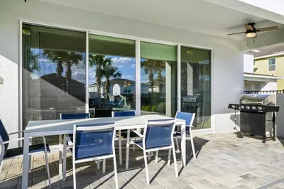 a patio with a table and chairs and a grill at Magnificent Home With Private Pool, Theater & Game Room Near Disney With Waterpark & Resort Access At Encore Resort - 230Bu in Kissimmee