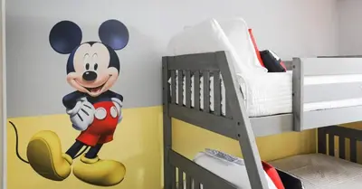 a bedroom with a mickey mouse mural on the wall at Casa 4Q | Piscina Privativa | 10 min da Disney in Kissimmee