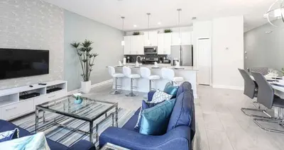 a living room with a blue couch and a table at Casa 4Q | Piscina Privativa | 10 min da Disney in Kissimmee