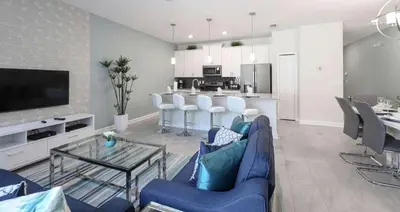 a living room with a blue couch and a kitchen at Casa 4Q | Piscina Privativa | 10 min da Disney in Kissimmee