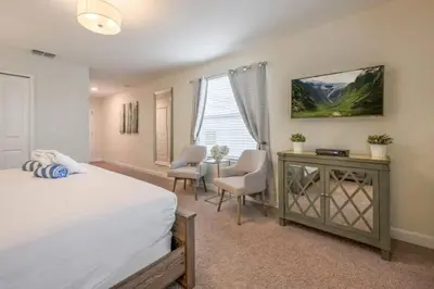 a bedroom with a bed and a table and chairs at Casa 5Q | Piscina Privativa & Vista para o Lago in Kissimmee
