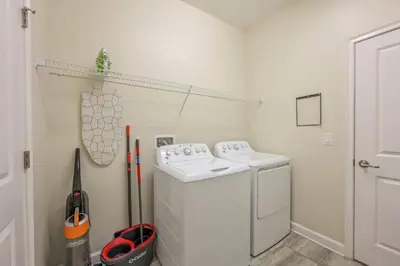 a white laundry room with a washer and dryer at Casa 5Q | Piscina Privativa & Vista para o Lago in Kissimmee