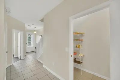 a hallway with white walls and a white staircase at Perfect Townhome Near Disney in Orlando