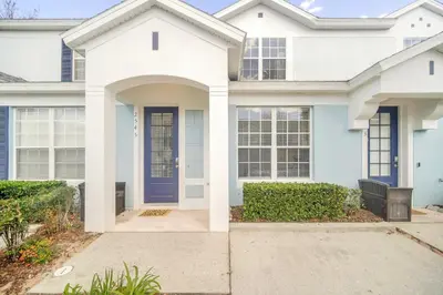 a white house with a blue door at Perfect Townhome Near Disney in Orlando