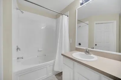 a white bathroom with a sink and a tub and a shower at Perfect Townhome Near Disney in Orlando