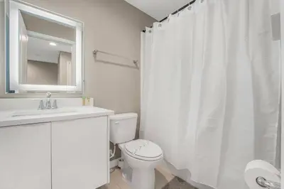 a bathroom with a toilet and a sink and a mirror at Cozy home in the best location of orlando in Kissimmee